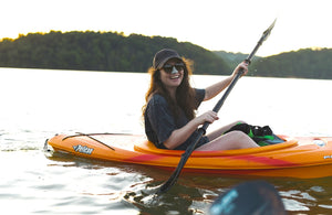 Smiling laughing girl wearing Noz: SPF Sunscreen. cruelty free, vegan & reef friendly uv protection paddling in a canoe on a lake.